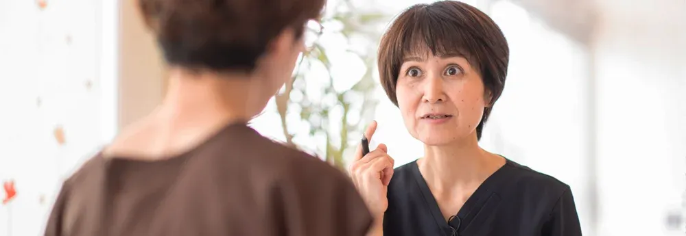 突発性難聴の治療について説明する鍼灸師
